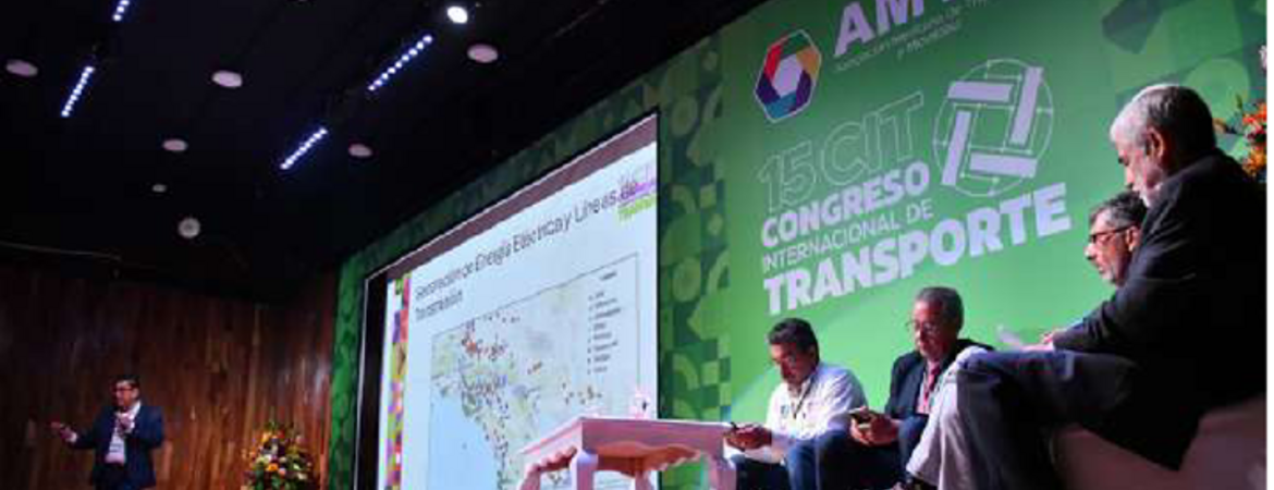 A speaker presents at the 15th International Transport Congress in Mexico City, with four panelists seated on stage next to a large screen displaying a map. The AMTM logo and event name are visible in the background.