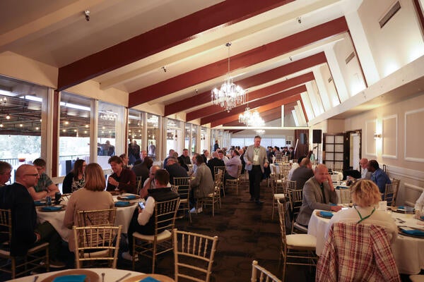 Conference attendees seated at round tables during the evening networking banquet at Canyon Crest Country Club, Riverside, CA.