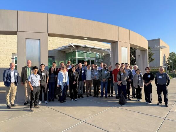 Group photo of more than 50 researchers, agency leaders, and policymakers standing outside the CE-CERT building during the OMEGA Dissemination Workshop, December 11, where CE-CERT presented findings on freight emissions monitoring, air quality impacts, and mitigation strategies in Inland Southern California.