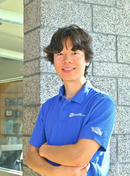 man with blue uc riverside shirt smiling with arms crossed headshot