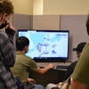 A few students learning about the electric grid on a computer