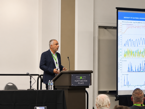 Georgios Karavalakis presents research at the Fall 2026 North American Hydrogen Engine Conference at Huntington Place, with UCR emissions data displayed on the screen beside him.