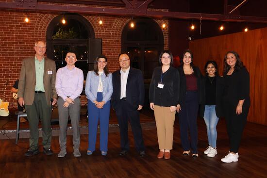 8 people standing in front of stage at IEEE FISTS 2024