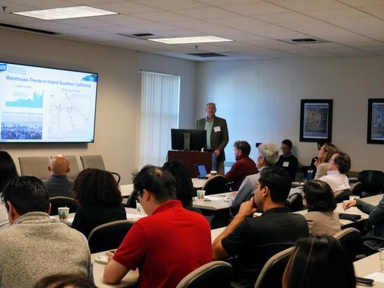 Audience members listen as a CE-CERT researcher presents OMEGA freight emissions research during the Dissemination Workshop.