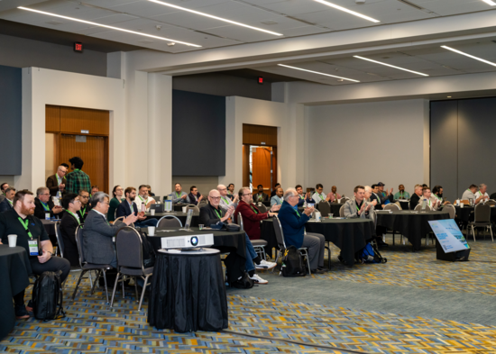 Attendees at the Fall 2026 North American Hydrogen Engine Conference sit at tables and applaud during a session at Huntington Place in Detroit.