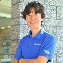 man with blue uc riverside shirt smiling with arms crossed headshot